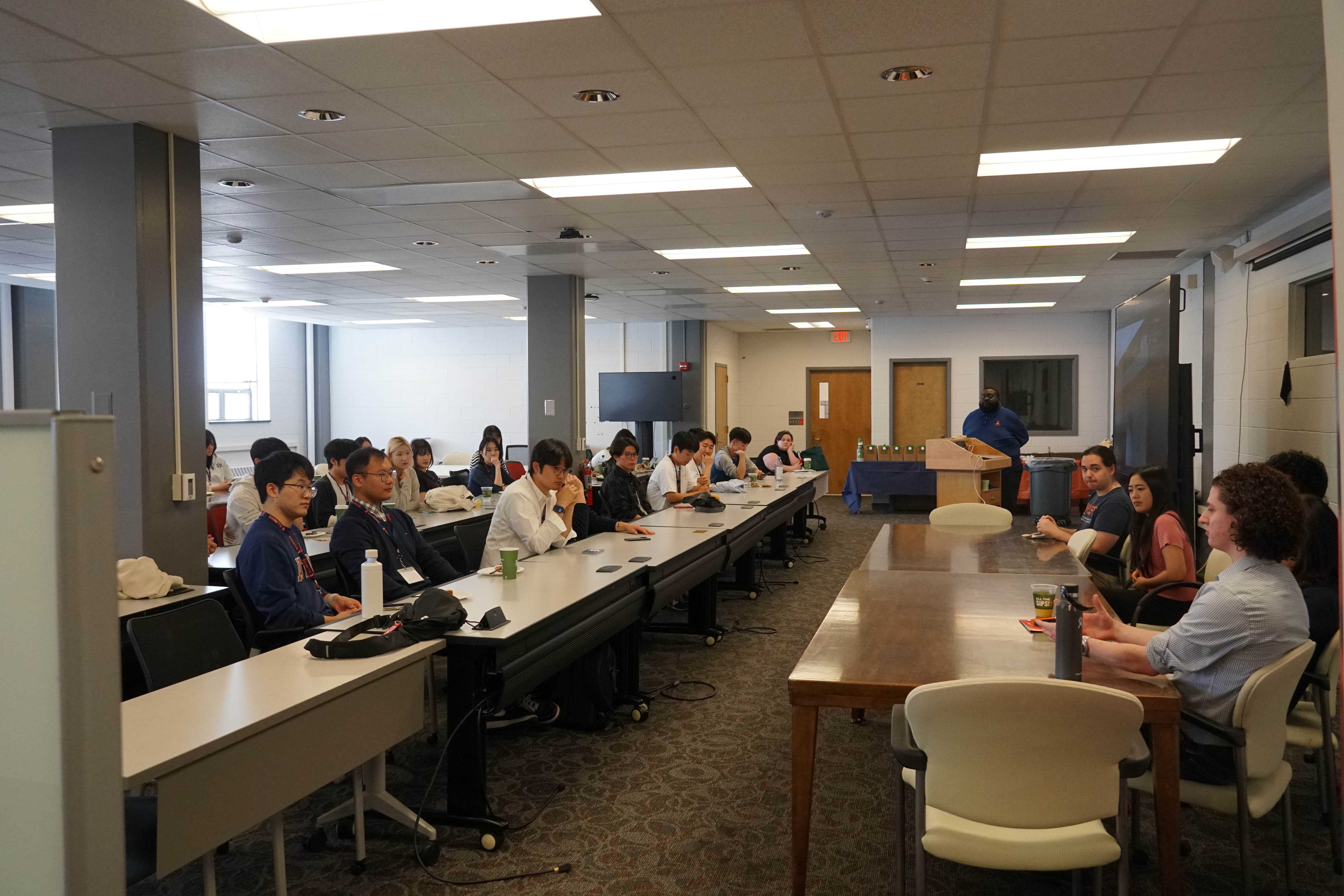 A room filled with undergraduate students from Korea listening to IQUIST researchers in a Q and A panel.