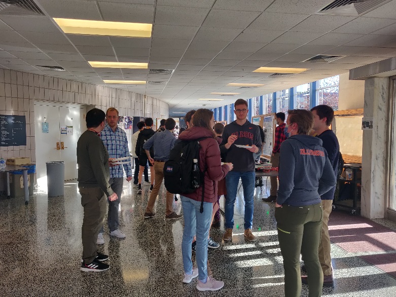 A group of people standing in a roomDescription automatically generated with medium confidence
