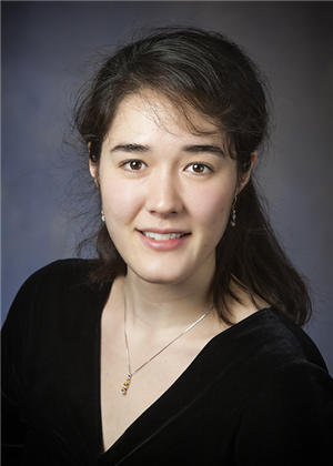 Photo shows woman with long dark hair smiling