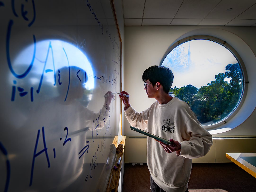 Stretching his mental math muscles, a student works out a combinatorics math permutation problem in a study room at the  Funk Aces Libary.