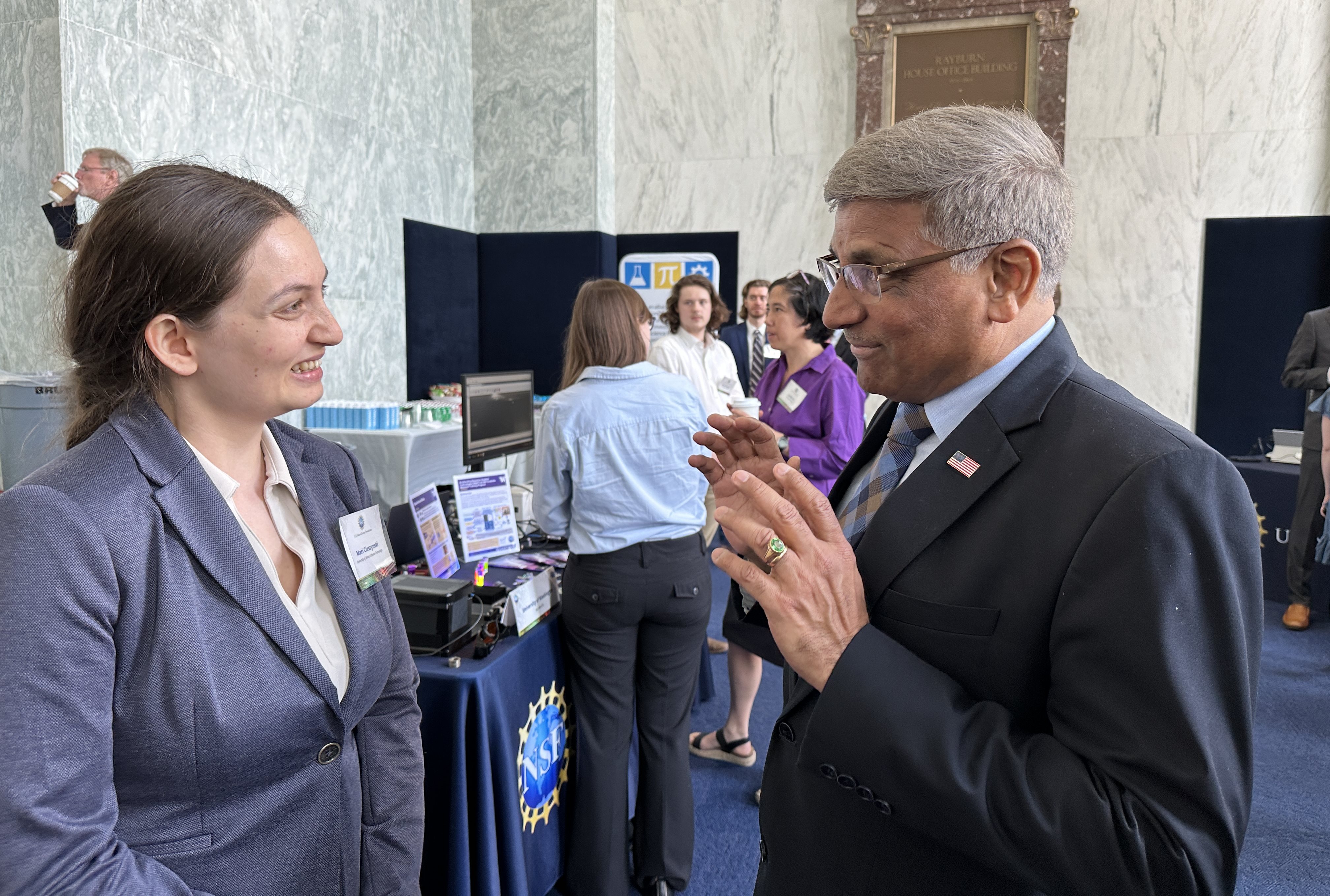 An older man and a younger woman speak with each other.